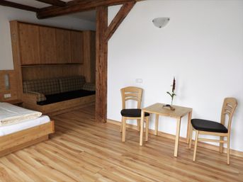 Zimmer mit Bett und zwei Stühlen