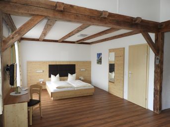 Offenes Doppelzimmer mit offenen Holzbalken an der Decke